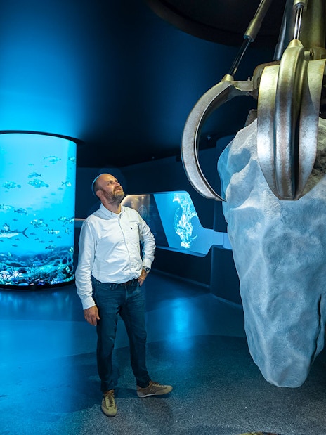 Man observing large claw sculpture at The View At The Palm exhibit.