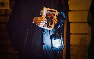 Guide holding lantern and brochure during Ghosts & Legends of Old Town Prague tour.