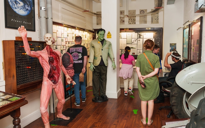 Visitors exploring exhibits at the National Wax Museum, including anatomical and Frankenstein figures.
