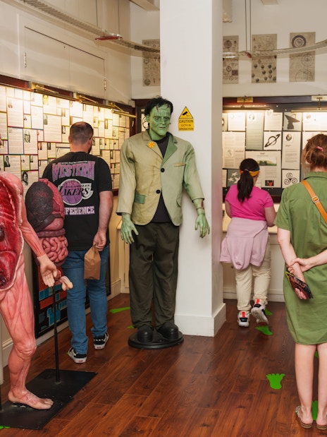 Visitors exploring exhibits at the National Wax Museum, including anatomical and Frankenstein figures.