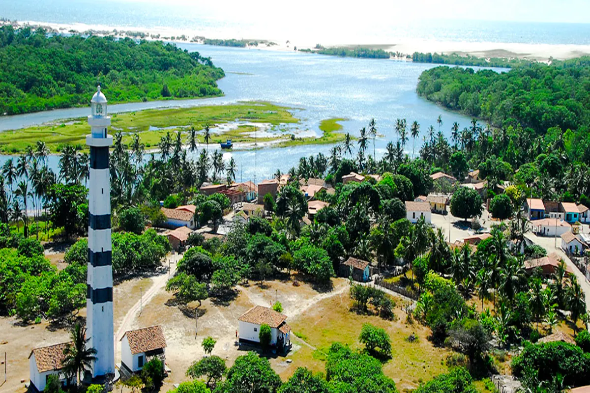 Mandacaru Lighthouse near Preguiças River with surrounding village and greenery, Sao Paulo.
