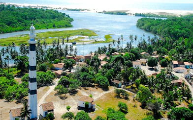 Mandacaru Lighthouse near Preguiças River with surrounding village and greenery, Sao Paulo.