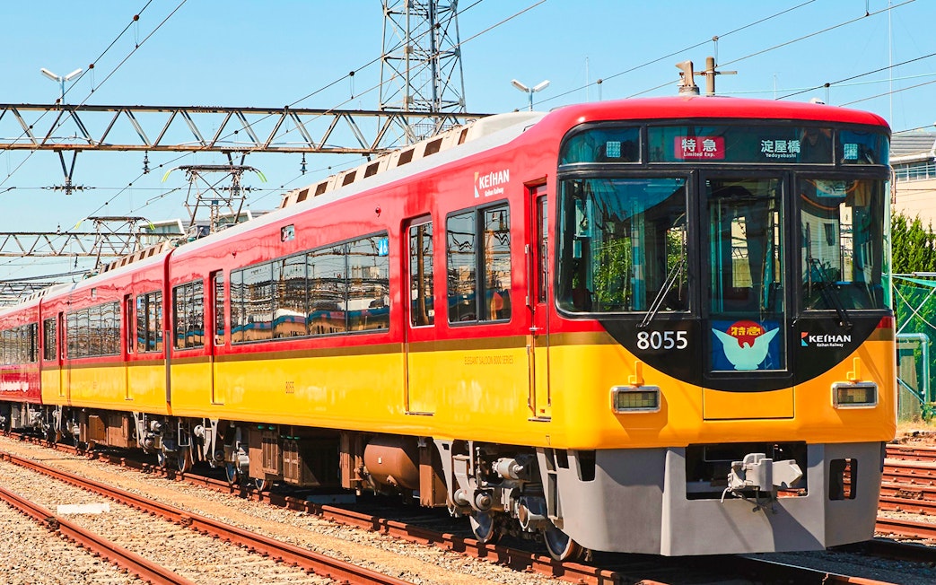 Kansai Railway train on tracks under clear sky.