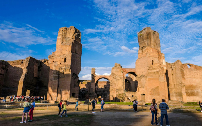 Terme di Caracalla ruins with tourists exploring, panoramic view in Rome, Italy.