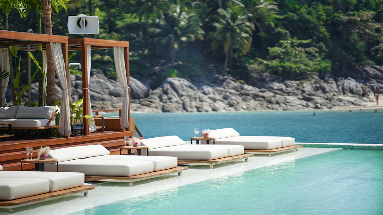 Tourists enjoying the Yona Beach Club Experience in Phuket, featuring a vibrant beach club with ocean views and exclusive amenities