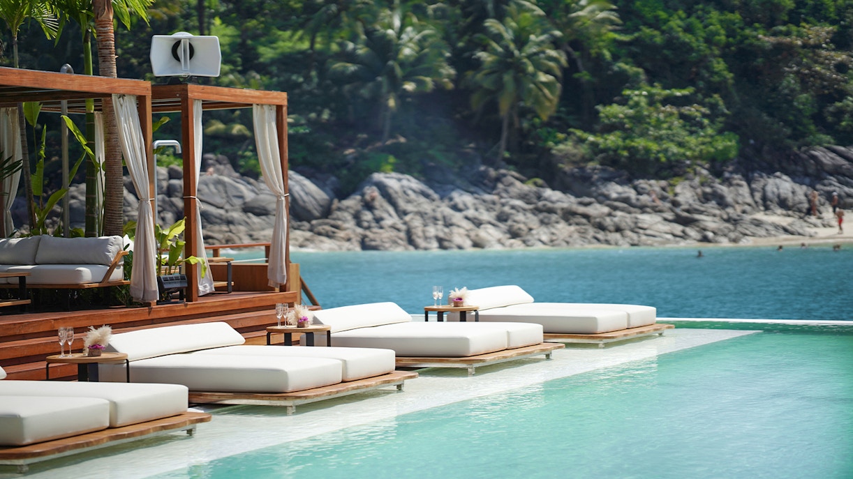 Tourists enjoying the Yona Beach Club Experience in Phuket, featuring a vibrant beach club with ocean views and exclusive amenities