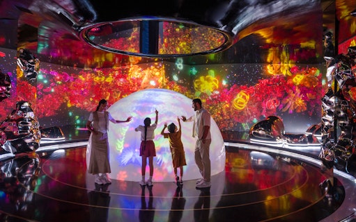 Family exploring interactive light display at AYA Universe.