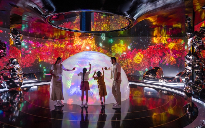 Family exploring interactive light display at AYA Universe.