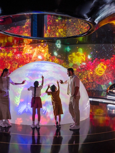 Family exploring interactive light display at AYA Universe.