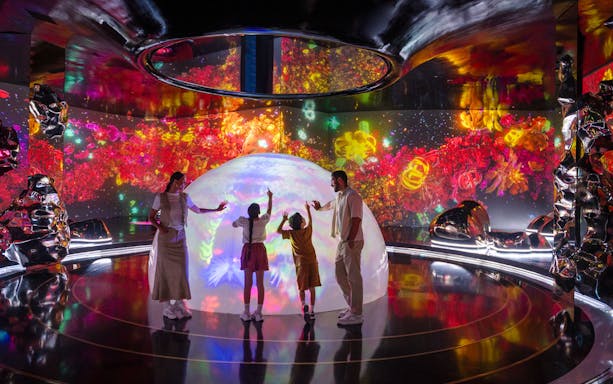 Family exploring interactive light display at AYA Universe.