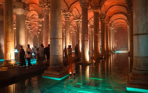 Visitors exploring the illuminated columns of Basilica Cistern in Istanbul.