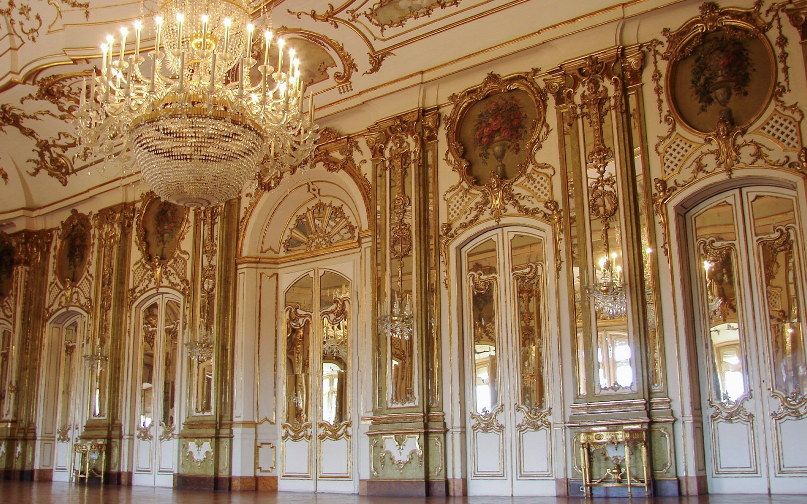 Der prunkvolle Spiegelsaal im Schloss Versailles mit hohen Spiegeln, Kronleuchtern und verzierten Decken.