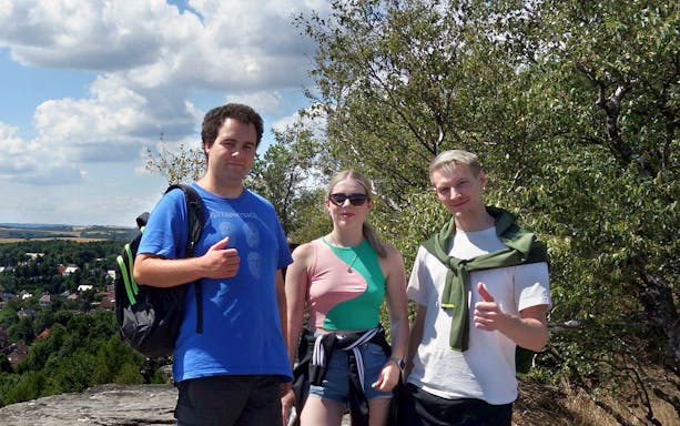 Group of tourists on a guided tour of Bastei Bridge and Tisa Walls Labyrinth, surrounded by trees.