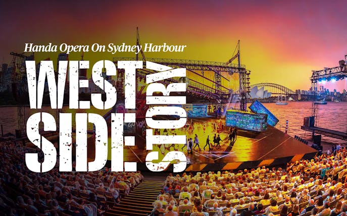 Open-air performance of West Side Story on Sydney Harbour with city skyline backdrop.