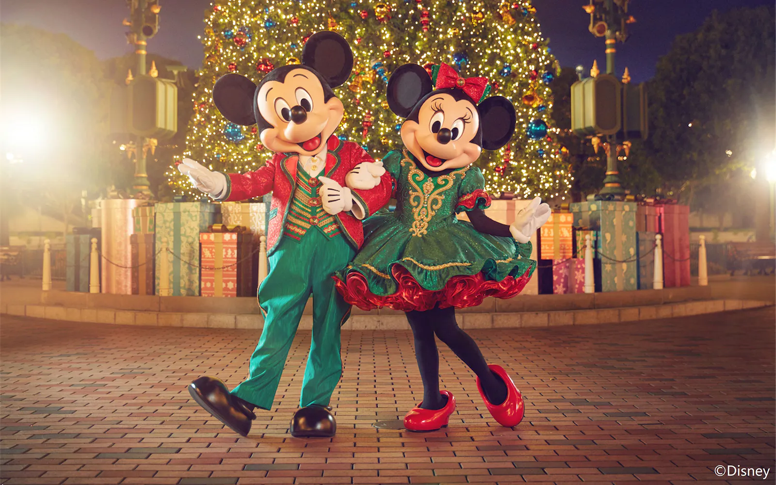 Mickey and Minnie Mouse in festive outfits at Disneyland Hong Kong Christmas display.