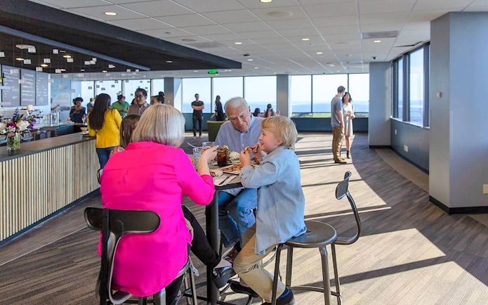 Visitors dining at Sky View Observatory cafe with panoramic city views.