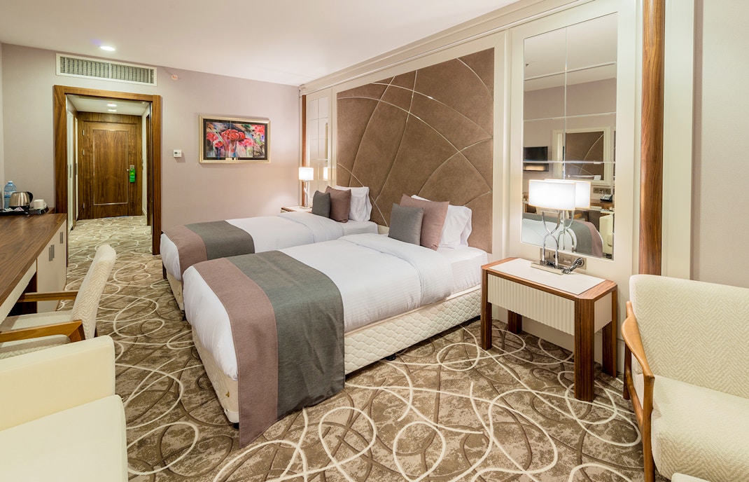 Mid range hotel room with double bed, desk and mirrors