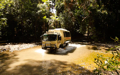Tour vehicle crossing a stream in Daintree Rainforest, Billy Tea Safaris, Cape Tribulation.