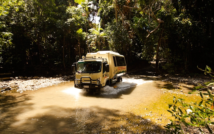 Tour vehicle crossing a stream in Daintree Rainforest, Billy Tea Safaris, Cape Tribulation.