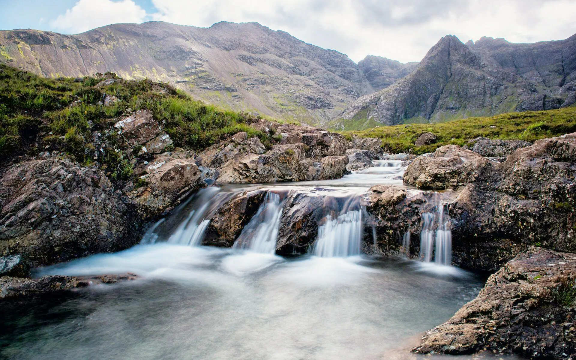 Waterfalls cascading over rocks at the Fairy Pools, Isle of Skye, Scotland.