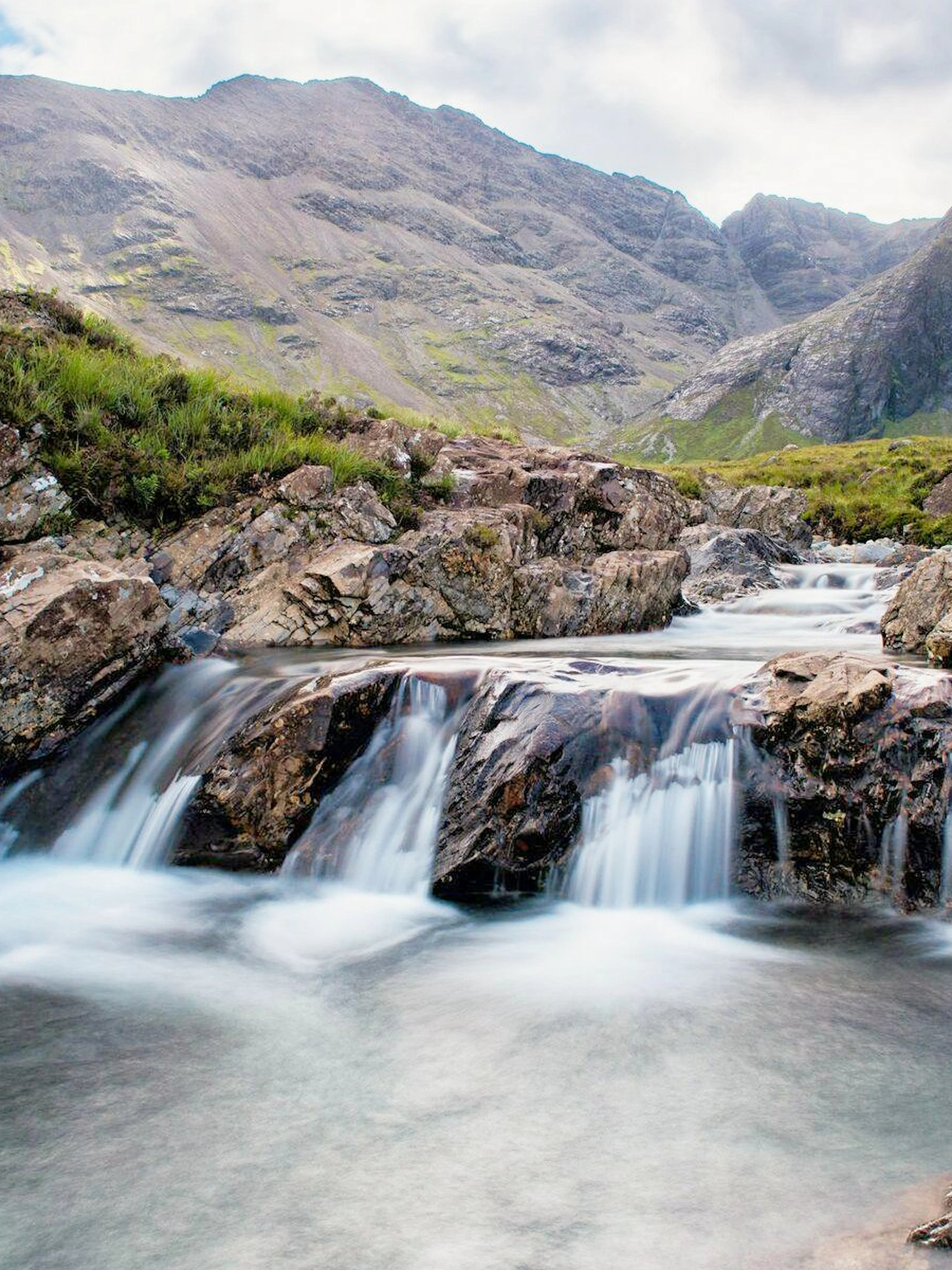 Waterfalls cascading over rocks at the Fairy Pools, Isle of Skye, Scotland.