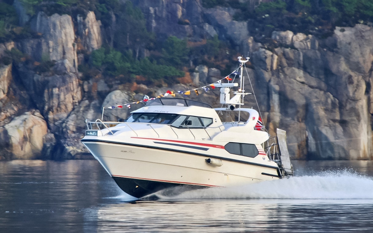 Cruise boat on Lysefjord with rocky cliffs in the background, Norway.