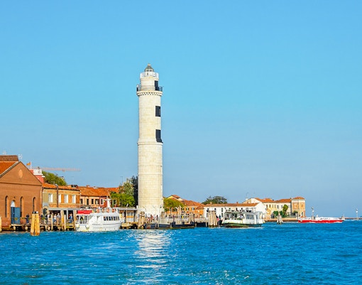 Faro di Murano lighthouse in Venice, Italy, with a view of the surrounding lagoon.