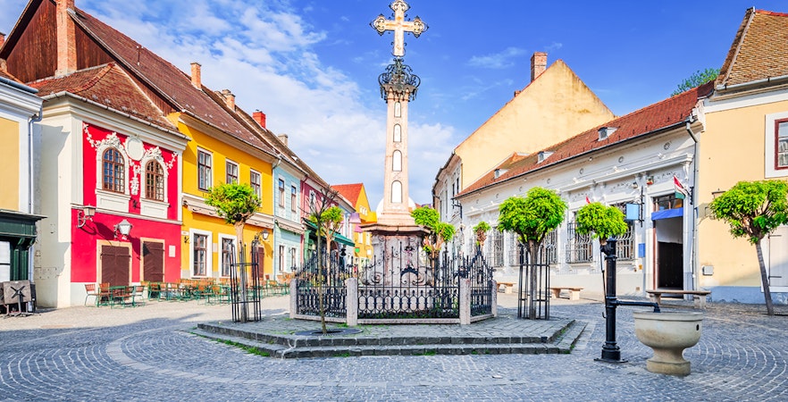 Szentendre village center with colorful buildings and a central cross monument.