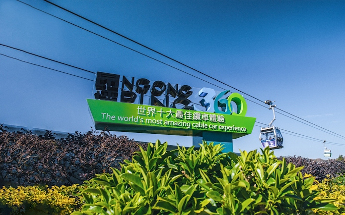 Ngong Ping 360 sign with cable cars in Hong Kong.