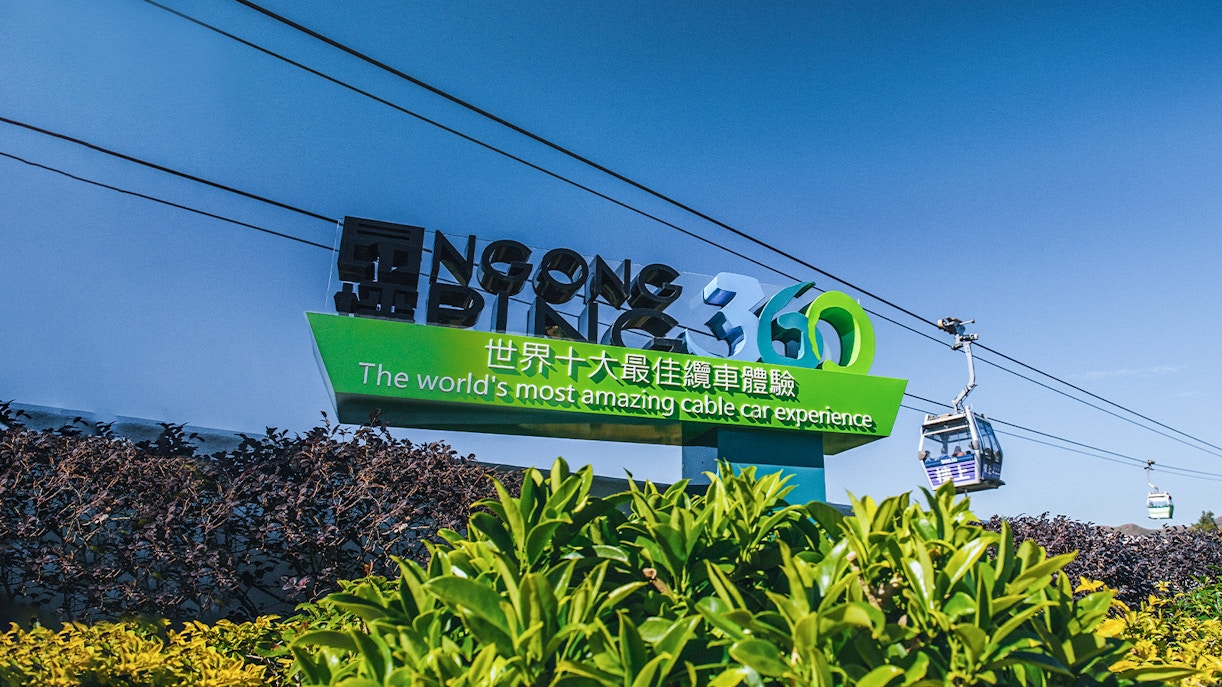 Ngong Ping 360 sign with cable cars in Hong Kong.
