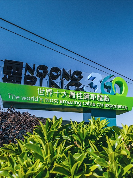 Ngong Ping 360 sign with cable cars in Hong Kong.