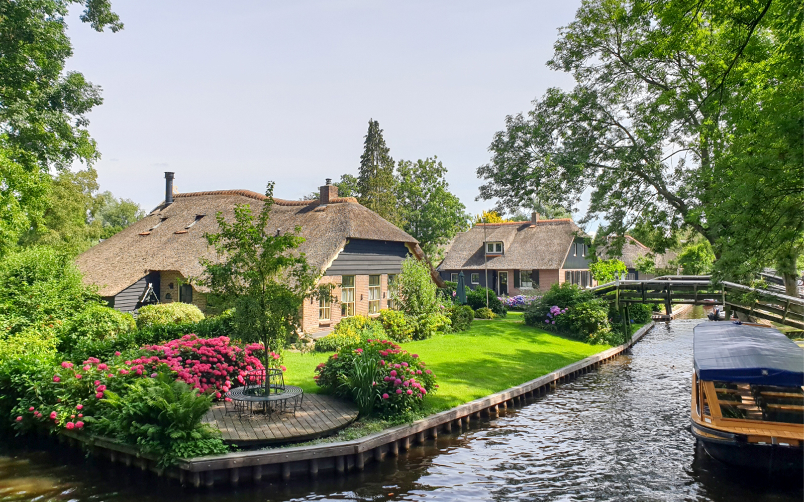 Thatched cottages and canal in Giethoorn, Netherlands, seen on a day trip from Amsterdam by bus and boat.