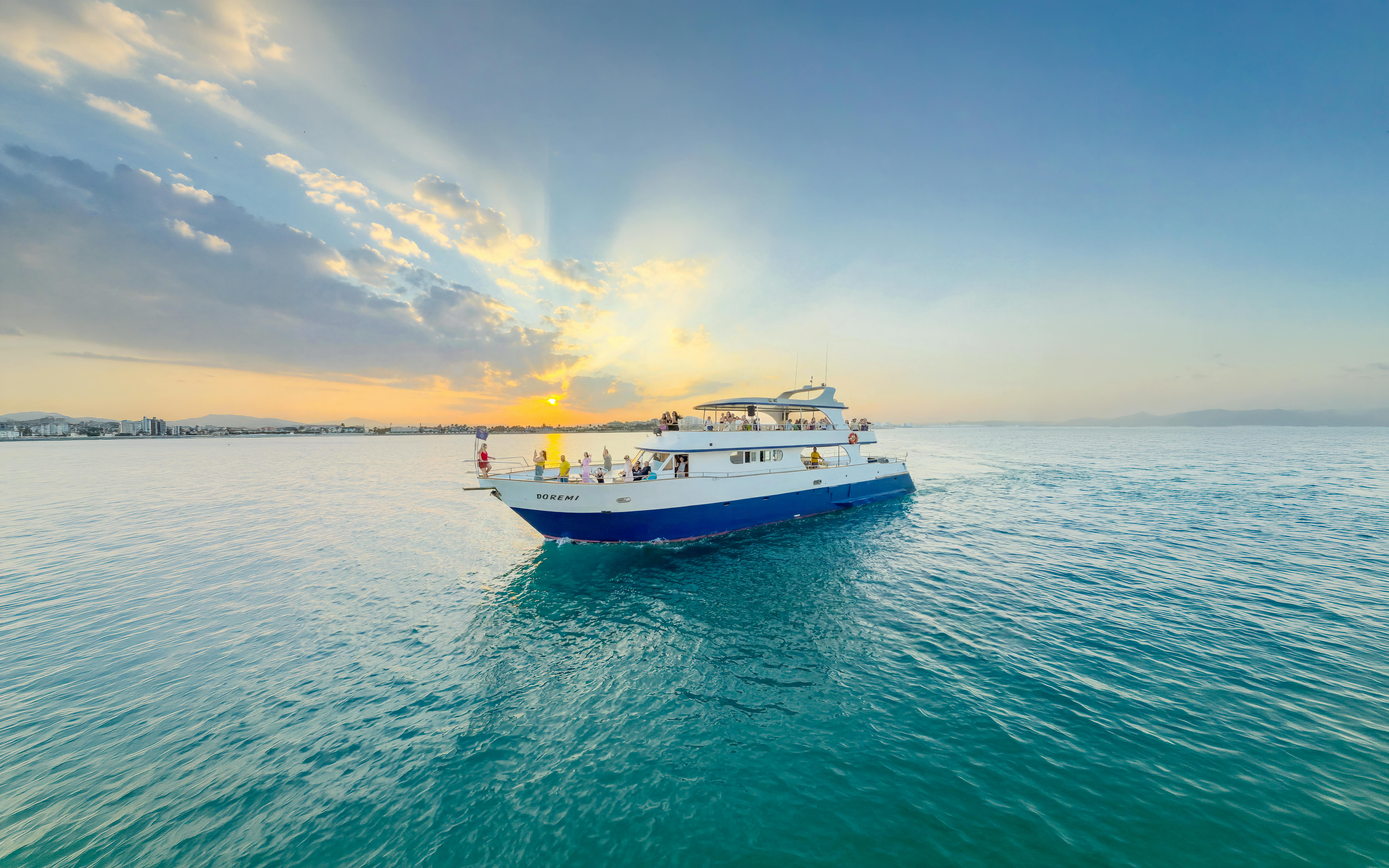 Sunset cruise boat on Larnaca waters with passengers enjoying the view.