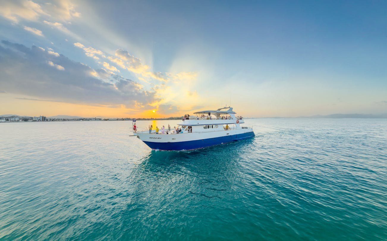 Sunset cruise boat on Larnaca waters with passengers enjoying the view.
