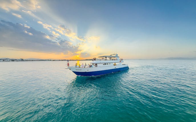 Sunset cruise boat on Larnaca waters with passengers enjoying the view.