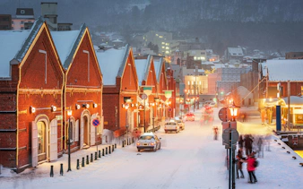 Snow-covered red brick buildings in the Warehouse District of Hakodate, Hokkaido, Japan.