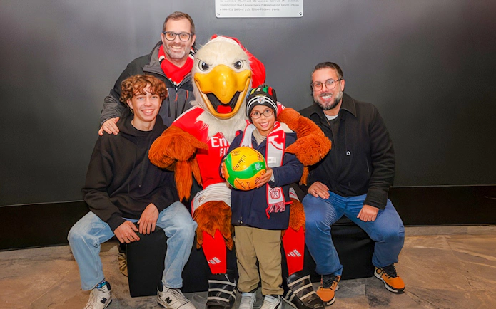 Family posing with SL Benfica mascot during stadium tour.