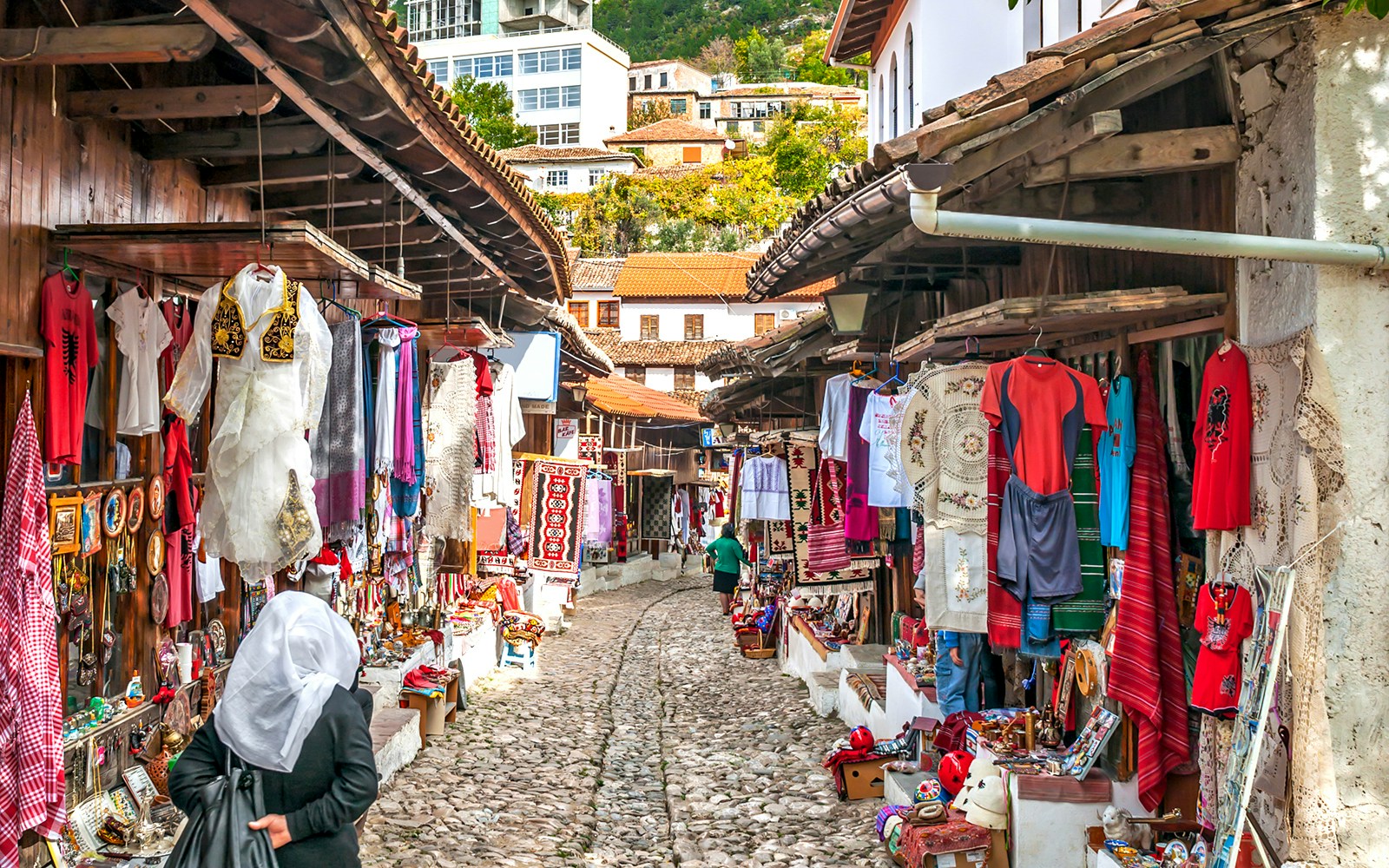 Cobblestone street with traditional market stalls in Old Town Kruja, Albania.