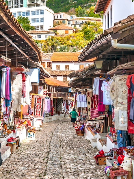 Cobblestone street with traditional market stalls in Old Town Kruja, Albania.