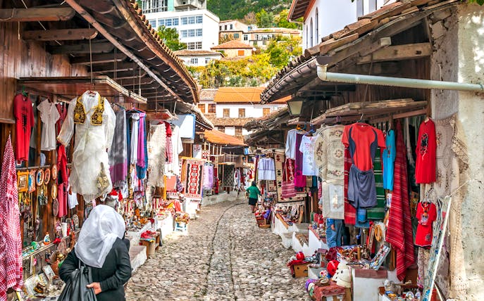Cobblestone street with traditional market stalls in Old Town Kruja, Albania.
