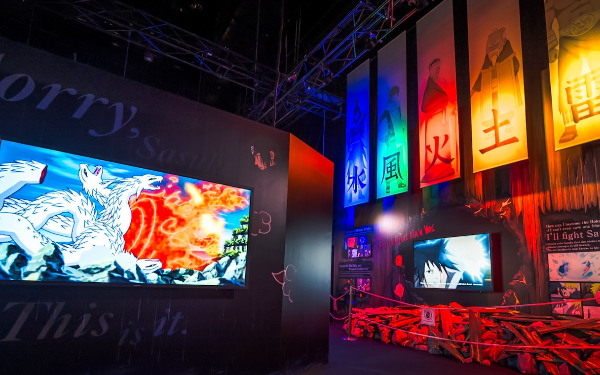Anime-themed exhibit at Universal Studios Singapore with colorful banners and screens.