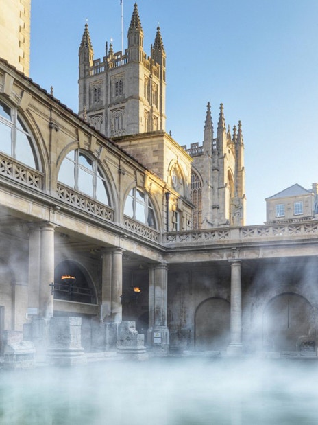 Roman Baths in Bath with steam rising, part of a day trip from London including Stonehenge and Windsor Castle.