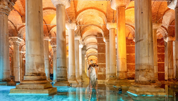 Pillars inside the Basilica Cistern in Istanbul with dimly lit arches and reflections on water.