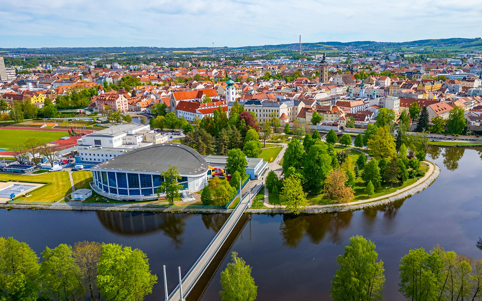 Panorama of Ceske Budejovice, Czech Republic, featuring a river, bridge, and historic buildings.