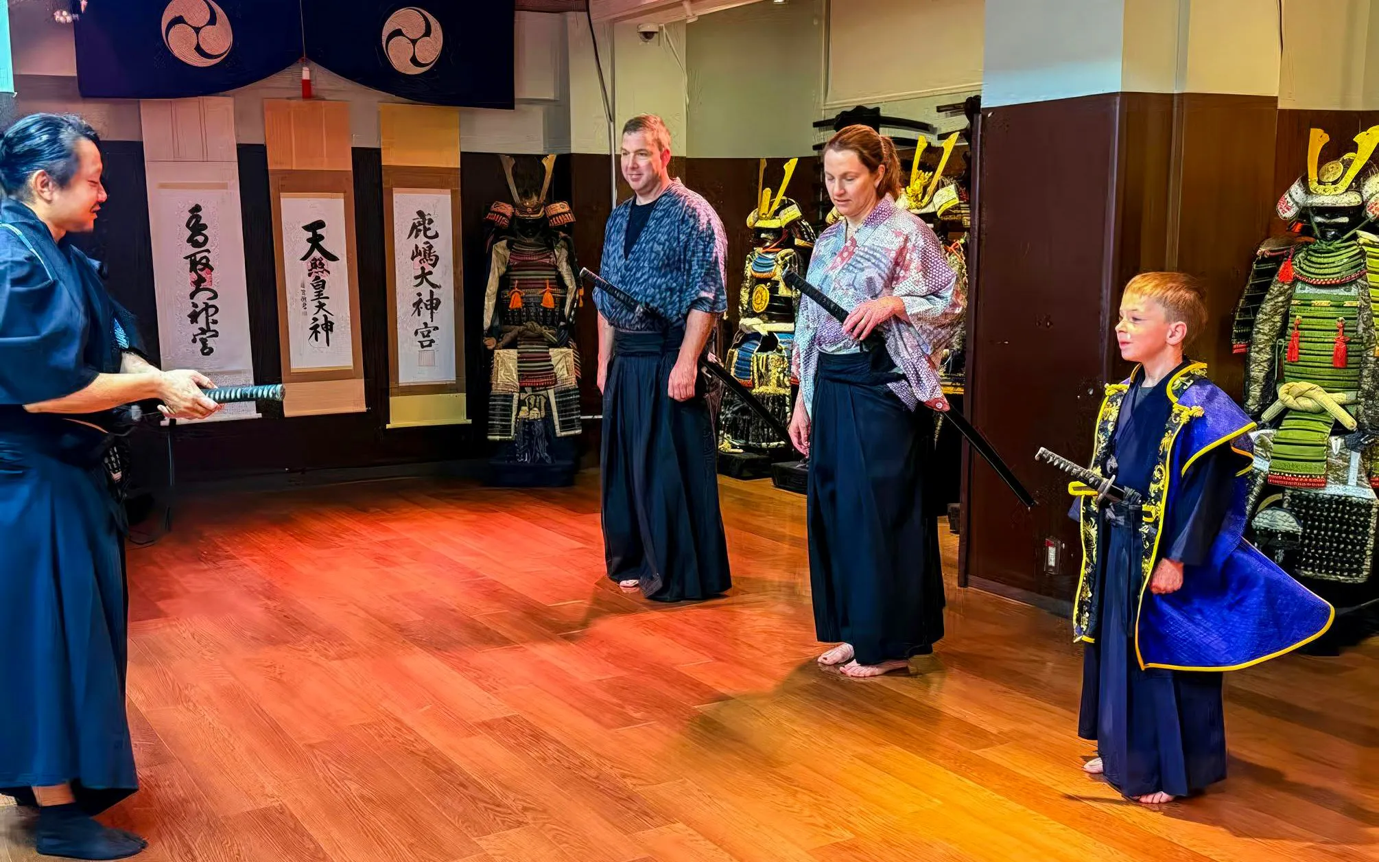 Participants in traditional attire learning sword techniques during a Samurai Experience in Japan.