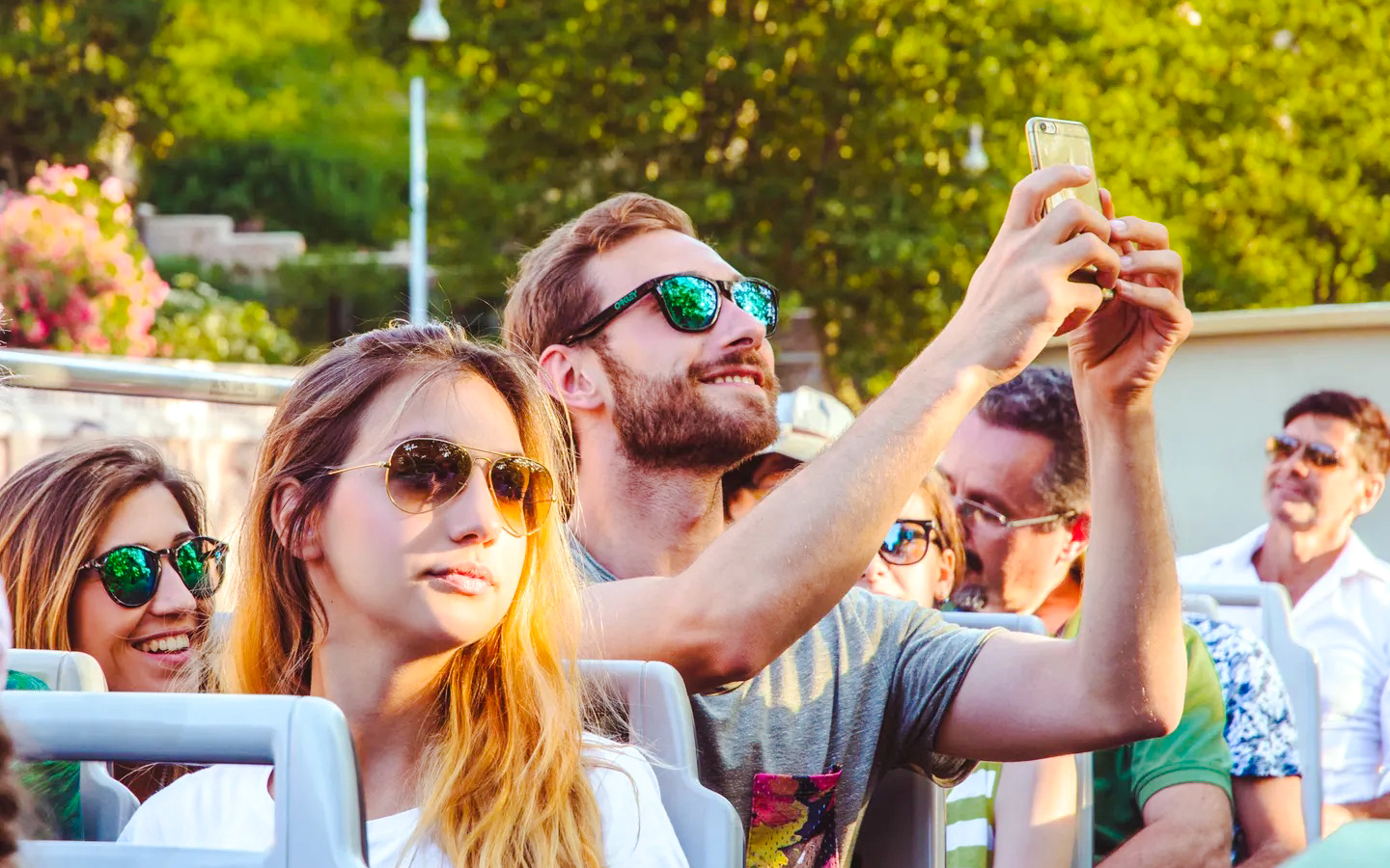 Person taking a photo on a phone during a hop-on hop-off bus tour.