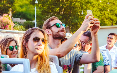 Person taking a photo on a phone during a hop-on hop-off bus tour.