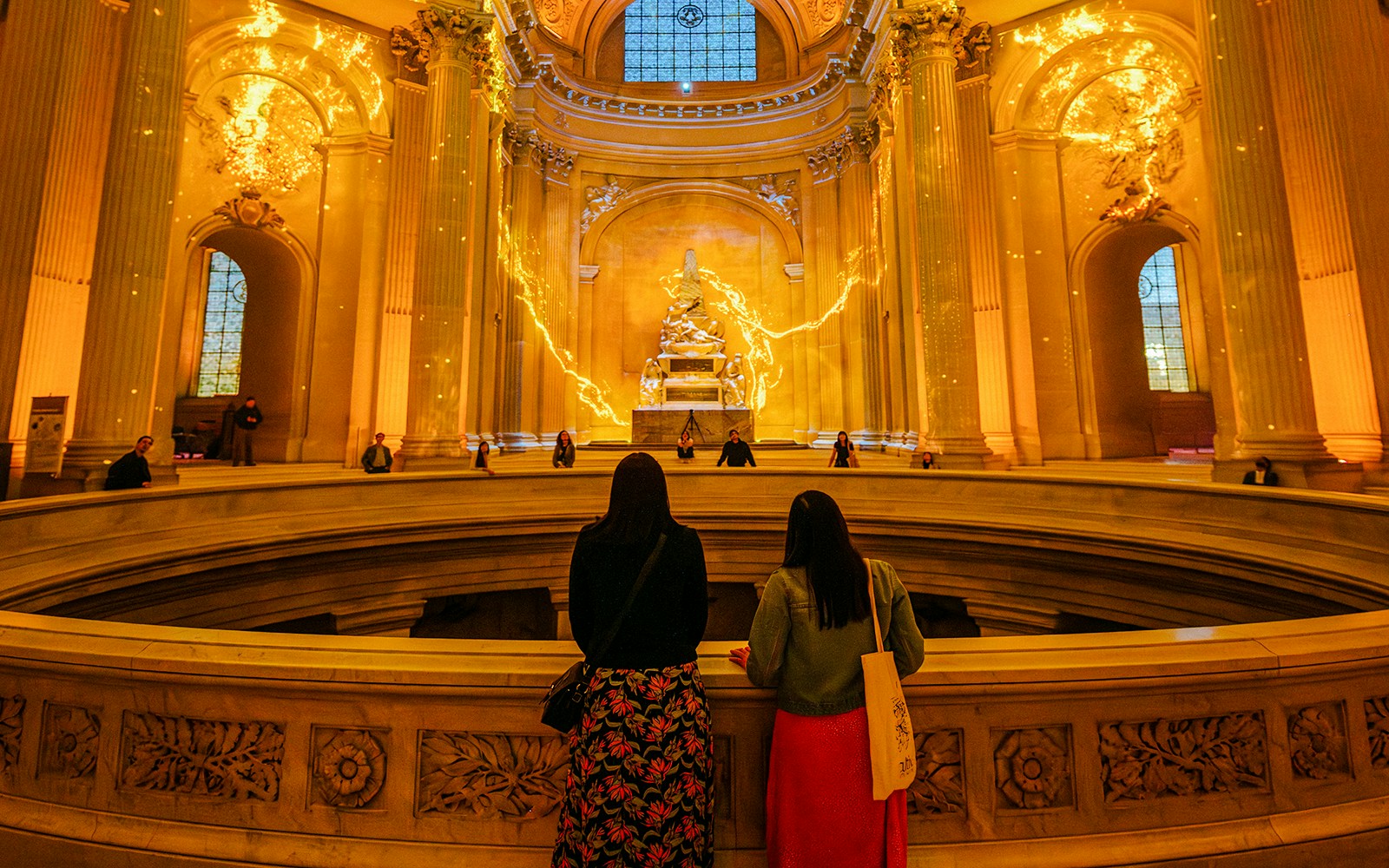 Visitors observing Aura Immersive light display at Invalides, Paris.