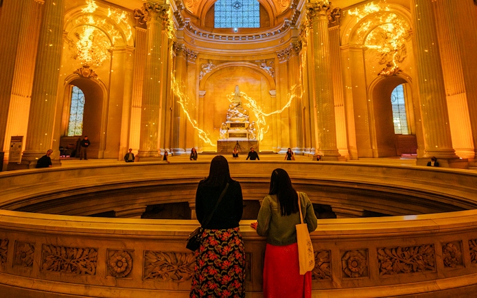 Visitors observing Aura Immersive light display at Invalides, Paris.