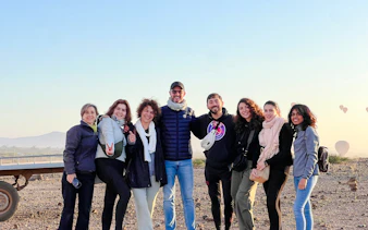 Group enjoying sunrise hot air balloon trip with Atlas Mountains in Marrakesh.